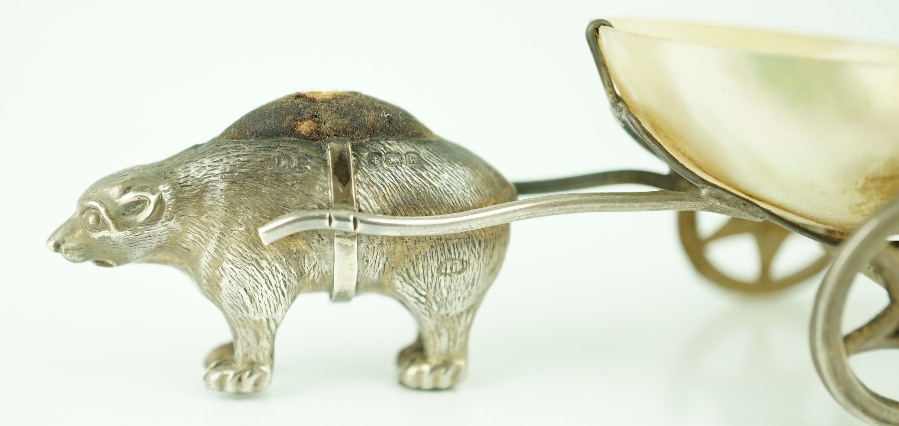 An Edwardian novelty silver and mother of pearl pin cushion, modelled as a bear pulling a cart, Adie & Lovekin Ltd